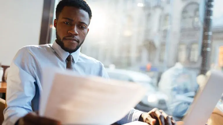 man reading paper at table