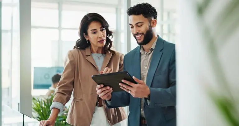 Two professionals discussing over tablet