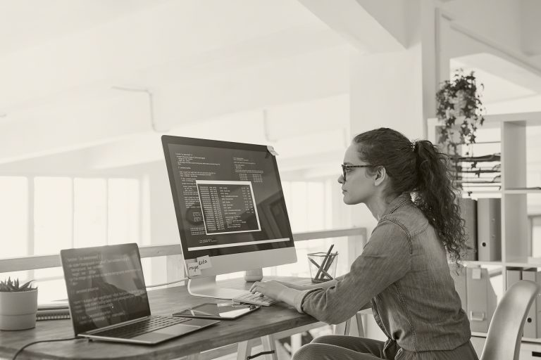 woman working on multiple screens