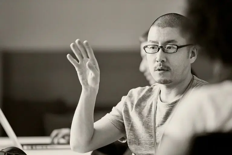 man raising hand in meeting