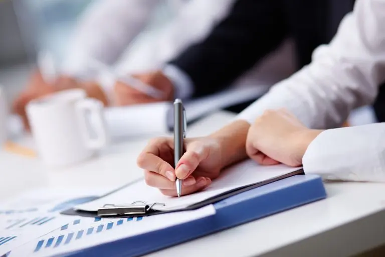 handwriting notes during meeting