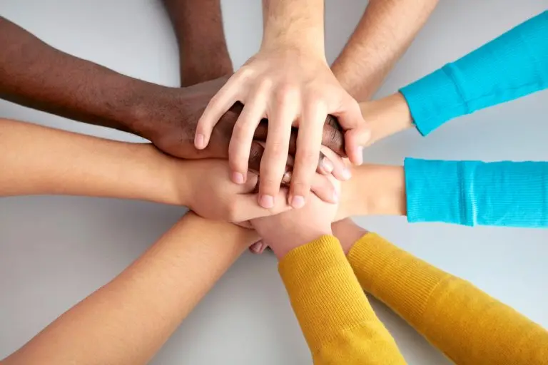 diverse hands stacked together teamwork