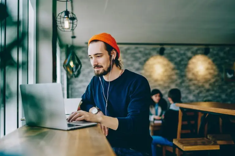 man using laptop in cafe