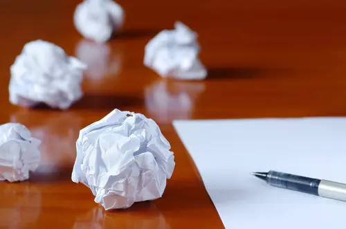 crumpled paper and pen