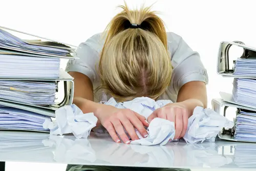 person stressed with paperwork