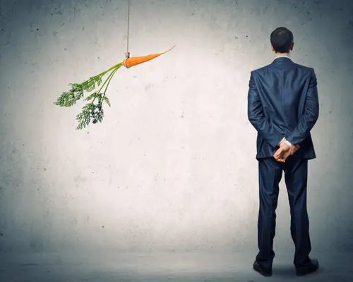 man looking at dangling carrot