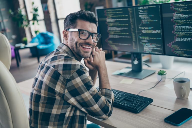smiling man with computer screens
