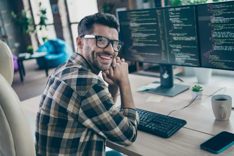 smiling man with computer screens