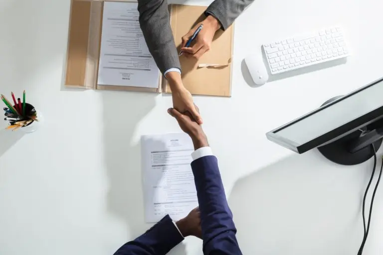 handshake over desk office documents