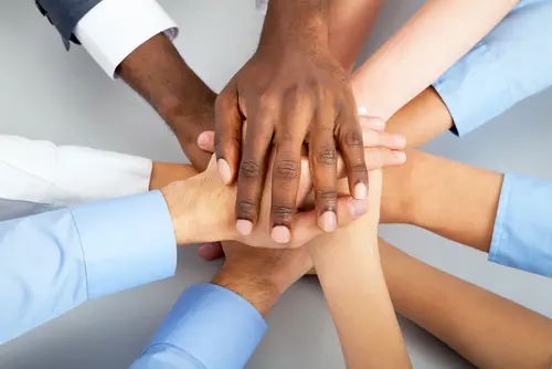 diverse hands stacked together teamwork
