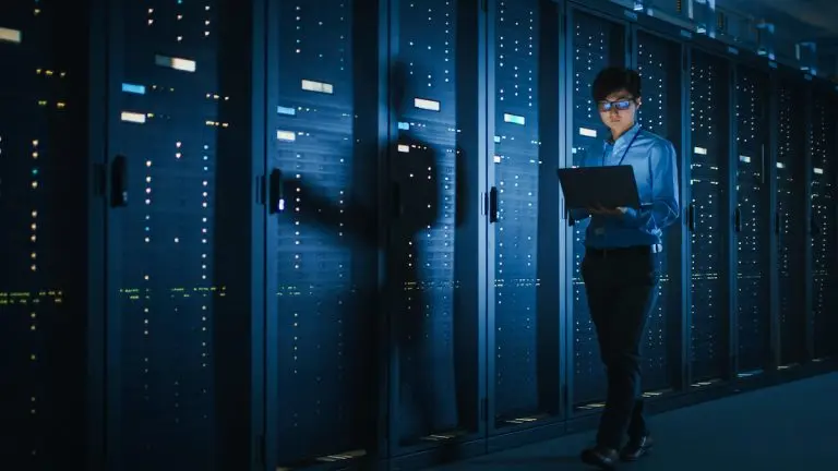 Man using laptop in server room