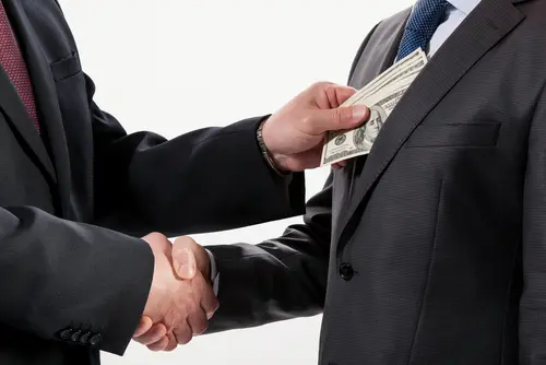 handshake concealing money exchange
