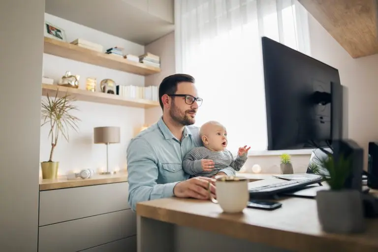 man holding baby at desk
