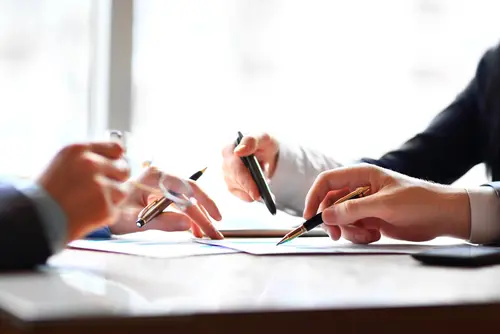 hands writing and discussing documents
