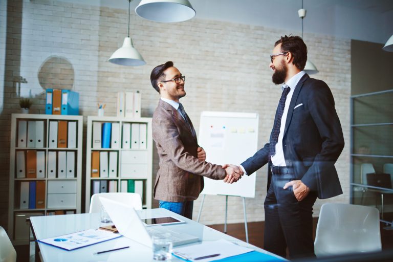 Businessmen shaking hands in office