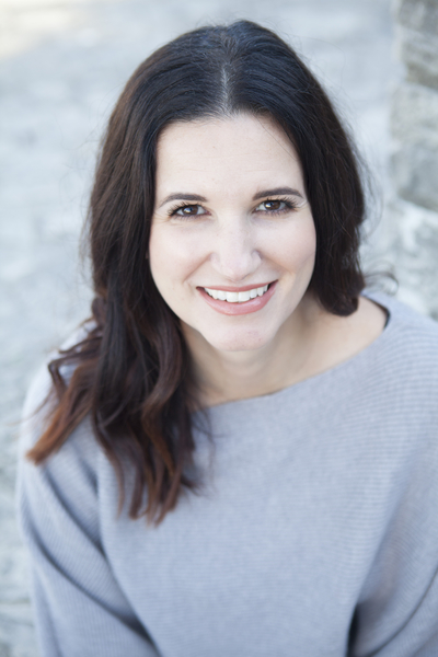 Professional woman smiling outdoors in casual gray sweater - tech lifestyle image.