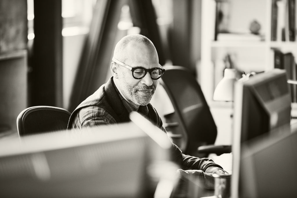 Gen Y technologist working with multiple monitors in modern tech office.